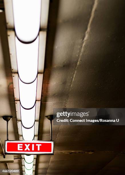 exit sign and fluorescent lights on ceiling of subway station, toronto, ontario, canada - luce fluorescente foto e immagini stock