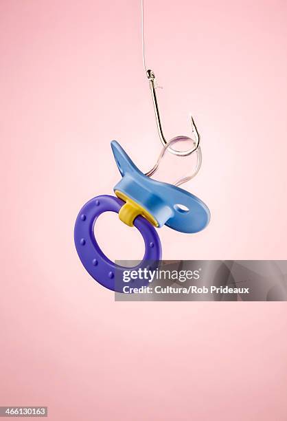 still life of dummy attached to fishing hook - pacifier stockfoto's en -beelden