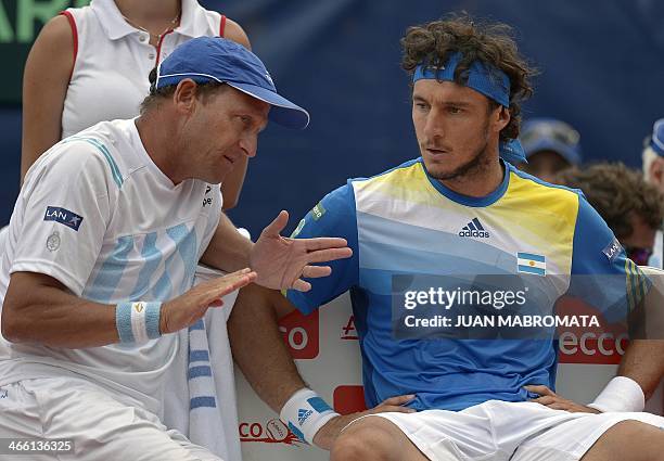 Argentina's tennis captain Martin Jaite talks to Argentina's tennis player Juan Monaco during their Davis Cup World Group 1st Round single tennis...