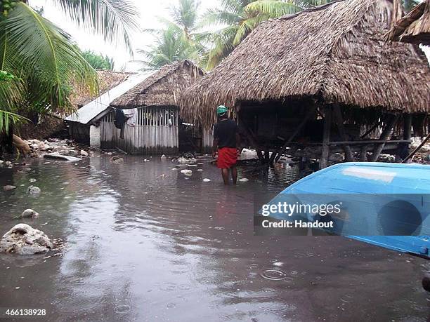 In this handout image provided by Plan International Australia, a man stands in flood waters March 13, 2015 on the island of Kiribati. Cyclone Pam is...