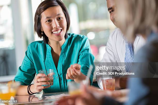 asiatische frau mit einer gruppe von menschen in einem restaurant bar - cocktails bar lounge stock-fotos und bilder