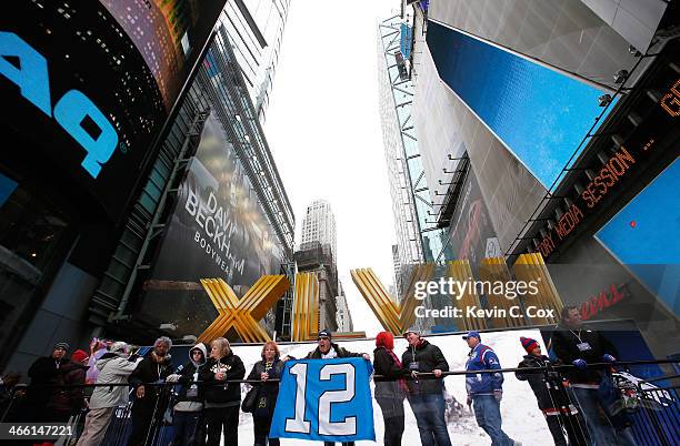 Fan pose for pictures in front of a Super Bowl XLVIII logo in Times Square on January 31, 2014 in New York City. Broadway has temporarily been...