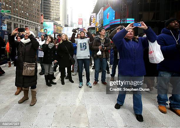 Fans take photos of Super Bowl signage in Times Square prior to Super Bowl XLVIII at MetLife Stadium on January 31, 2014 in New York City.