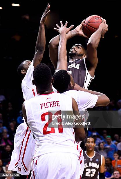 Marcus Posley of the St. Bonaventure Bonnies attempts a shot over Kendall Pollard and Dyshawn Pierre of the Dayton Flyers during a quarterfinal game...