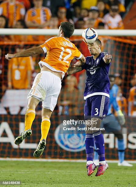 Will Bruin of Houston Dynamo battles for the ball with Seb Hines of Orlando City SC during their game at BBVA Compass Stadium on March 13, 2015 in...
