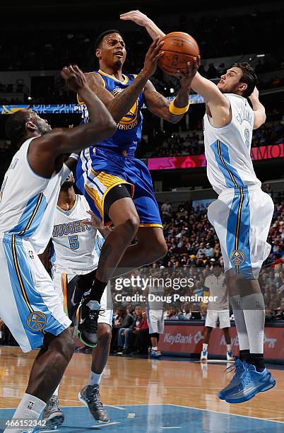 Brandon Rush of the Golden State Warriors lays up a shot against J.J. Hickson and Danilo Gallinari of the Denver Nuggets at Pepsi Center on March 13,...