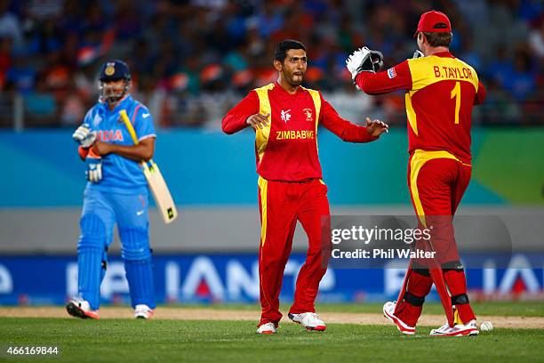 Sikandar Raza of Zimbabwe celebrates bowling Virat Kohli of India during the 2015 ICC Cricket World Cup match between India and Zimbabwe at Eden Park...