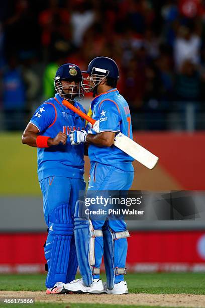 Suresh Raina and MS Dhoni of India at the end of the 2015 ICC Cricket World Cup match between India and Zimbabwe at Eden Park on March 14, 2015 in...