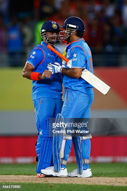 Suresh Raina and MS Dhoni of India at the end of the 2015 ICC Cricket World Cup match between India and Zimbabwe at Eden Park on March 14, 2015 in...