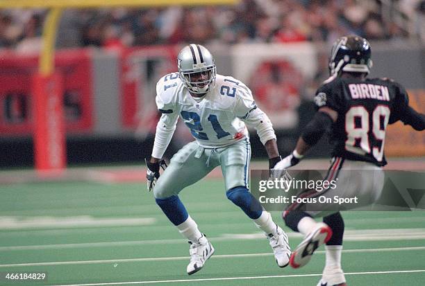 Dion Sanders of the Dallas Cowboys guards J.J. Birden of the Atlanta Falcons during an NFL football game October 29, 1995 at the Georgia Dome in...