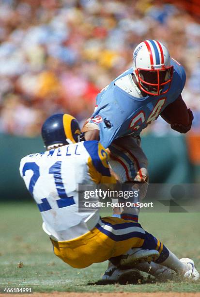 Earl Campbell of the Houston Oilers gets tackled by Nolan Cromwell of the Los Angeles Rams during an NFL Football game September 6, 1981 at Anaheim...