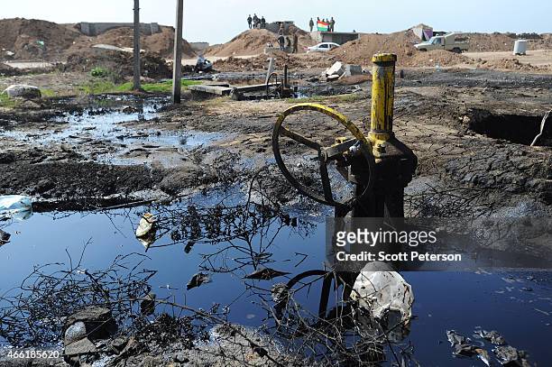 Peshmerga checkpoint is reflected in pools of oil with damaged oil pipeline infrastructure, as Iraqi Kurdish forces push the frontline forward...