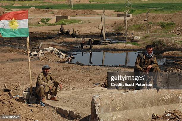 Peshmerga checkpoint stands beside pools of oil with damaged oil pipeline infrastructure, as Iraqi Kurdish forces push the frontline forward against...