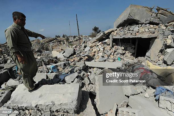 Peshmerga fighter points out remains of bodies rotting in a destroyed village once controlled by ISIS as Iraqi Kurdish forces push the frontline...