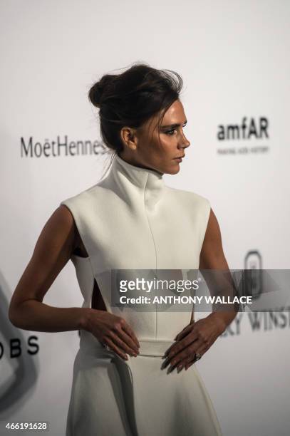 British fashion designer and singer Victoria Beckham poses as she arrives on the red carpet during the 2015 amfAR Hong Kong gala at Shaw Studios in...