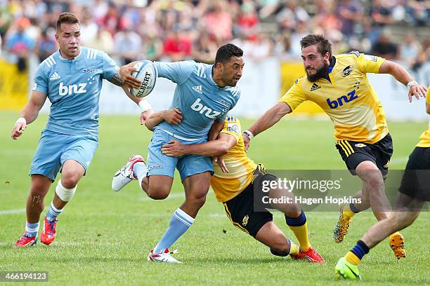 Benji Marshall of the Blues hits the defence of Tim Bateman and Andre Taylor of the Hurricanes during the Super Rugby Trial Match between the Blues...