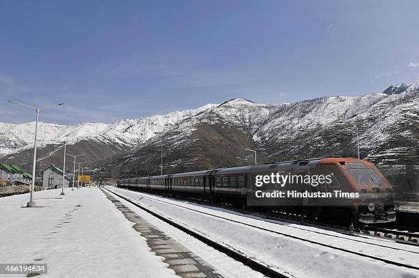Train passes through snow covered railway track with the back drop of Snow Mountain after a heavy snowfall in Banihal some 110 kms from Sringar, on...