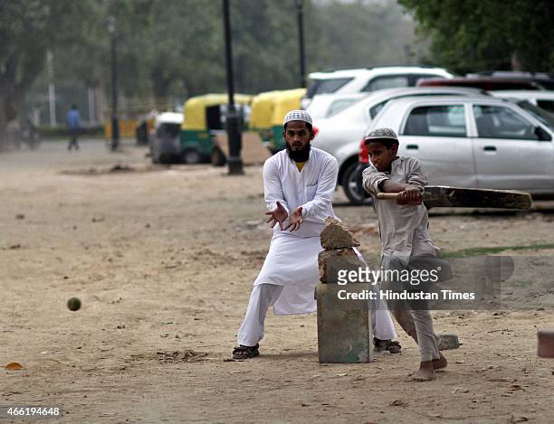 Muslim children playing cricket during a cloudy weather at India gate, on March 14, 2015 in New Delhi, India. The Met Office has forecast a cloudy...