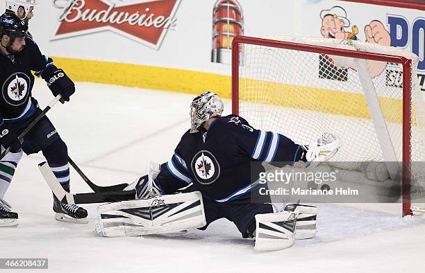 Jason Garrison of the Vancouver Canucks scores against Ondrej Pavelec of the Winnipeg Jets in third period action in an NHL game at the MTS Centre on...