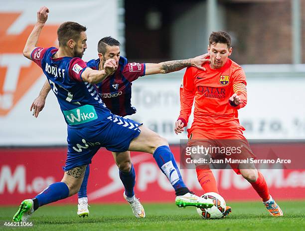 Lionel Messi of FC Barcelona duels for the ball with Didac Vila and Manuel Castellano Lillo'of SD Eibar during the La Liga match between SD Eibar and...