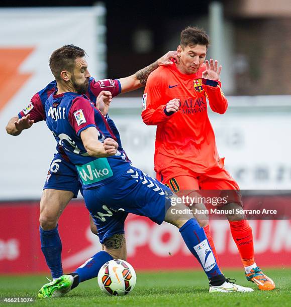 Lionel Messi of FC Barcelona duels for the ball with Manuel Castellano Lillo'of SD Eibar during the La Liga match between SD Eibar and FC Barcelona...