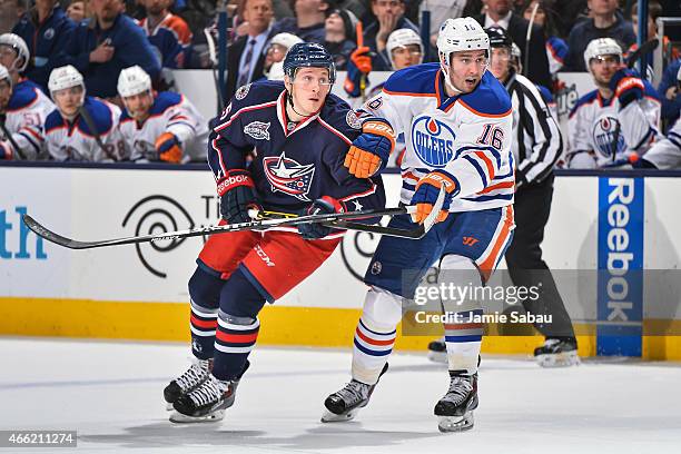 Luke Adam of the Columbus Blue Jackets skates and Teddy Purcell of the Edmonton Oilers battle for position on March 13, 2015 at Nationwide Arena in...