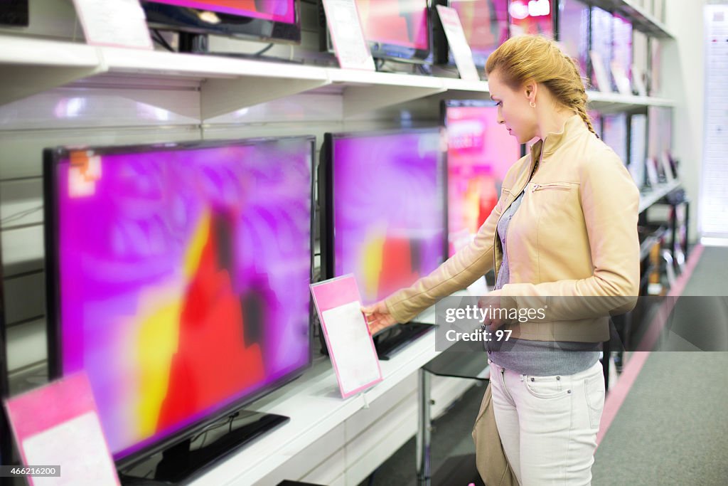 La mujer compra un televisor en la tienda
