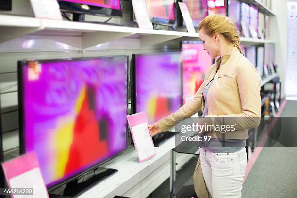 a mulher compra uma tv na loja - electronic imagens e fotografias de stock