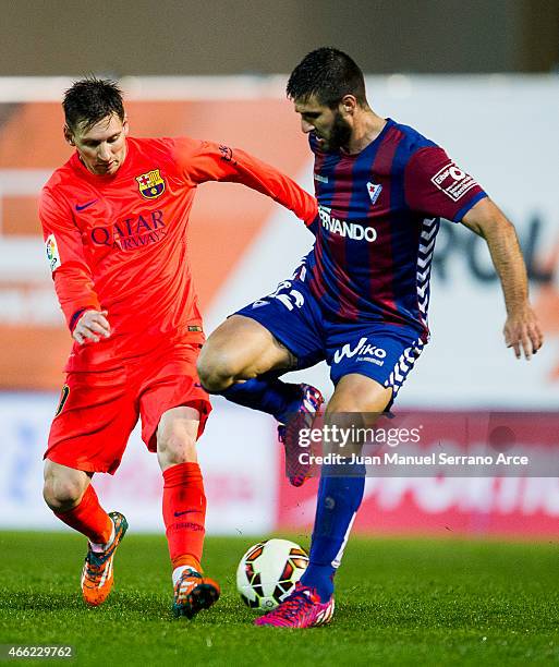 Lionel Messi of FC Barcelona duels for the ball with Raul Rodriguez Navas of SD Eibar during the La Liga match between SD Eibar and FC Barcelona at...