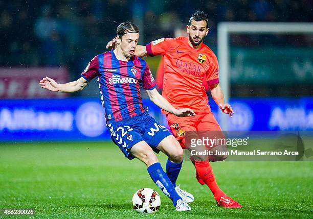 Martin Montoya of FC Barcelona duels for the ball with Javier Lara of SD Eibar during the La Liga match between SD Eibar and FC Barcelona at Ipurua...