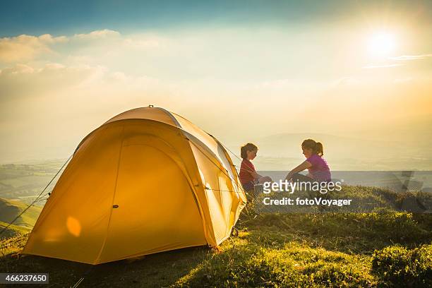 kinder camping gelbe zelt auf einer idyllischen lage am berg top sommer sonnenuntergang - girl mound stock-fotos und bilder