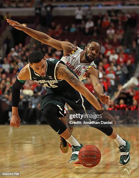 Denzel Valentine of the Michigan State Spartans is chased by Dez Wells of the Maryland Terrapins during the semifinal round of the 2015 Big Ten Men's...