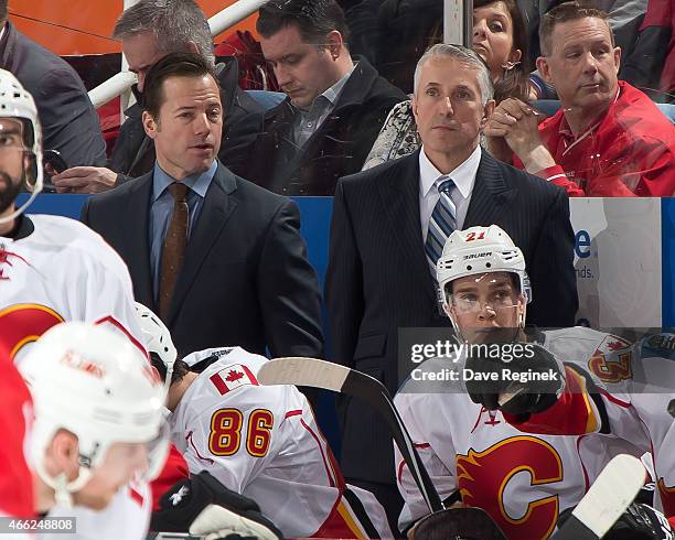 Assistant coach Martin Gelinas and head coach Bob Hartley of the Calgary Flames watch the action from the bench during a NHL game against the Detroit...