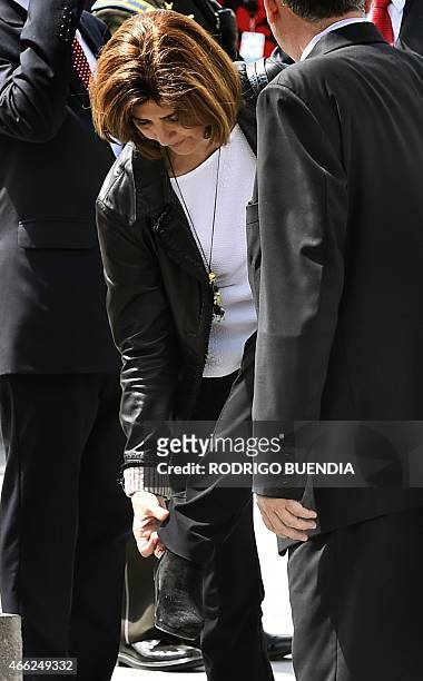 Colombia's Foreign Minister Maria Angela Holguin straightens her trousers upon arrival to take part in the UNASUR meeting in Quito, on March 14,...