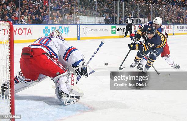 Tyler Ennis of the Buffalo Sabres fires a first period shot against Mackenzie Skapski of the New York Rangers while Marc Staal closes in on March 14,...