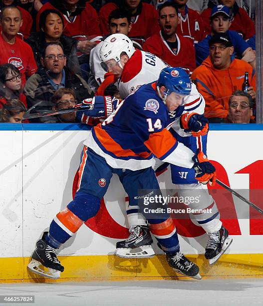 Brendan Gallagher of the Montreal Canadiens is hit into the boards by Thomas Hickey of the New York Islanders during the first period at the Nassau...