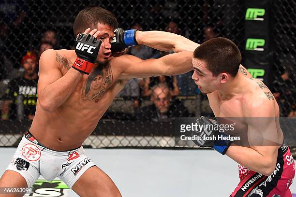 Ryan Benoit lands a punch to the face of Sergio Pettis in their flyweight bout during the UFC 185 event at the American Airlines Center on March 14,...