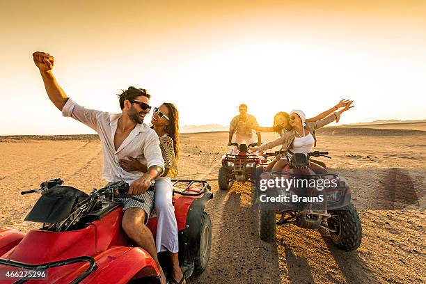 friends having fun riding quad bikes in desert - quadbike stock pictures, royalty-free photos & images
