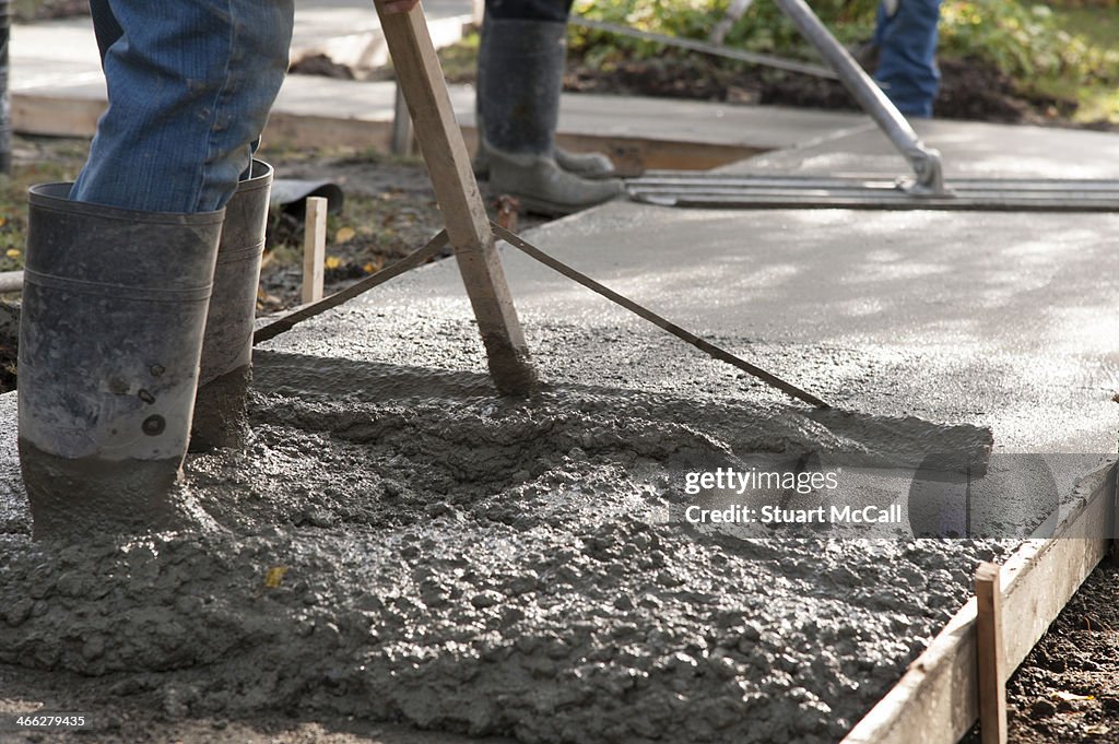 Concrete workers laying new sidewalk
