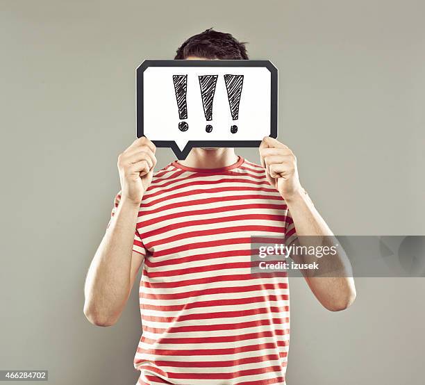 young man holding speech bubble with exclamation marks - good news banner stock pictures, royalty-free photos & images