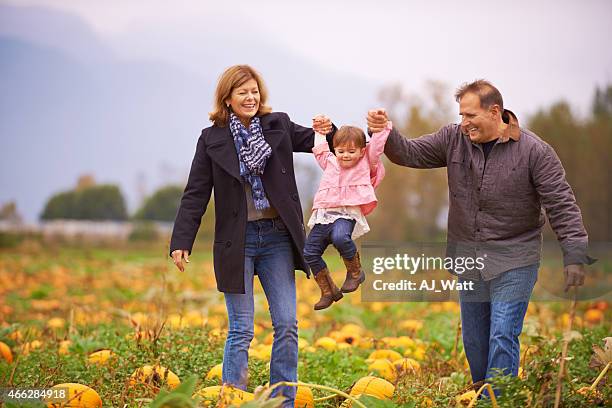 man and woman holding up a little girl with their hands - grandparents raising grandchildren stock pictures, royalty-free photos & images