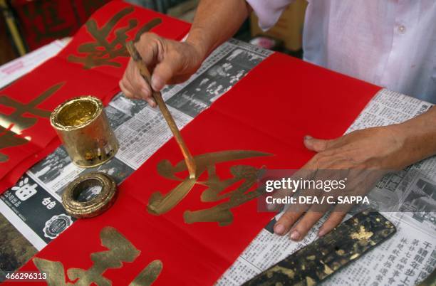 Handpainting a letter of the Chinese alphabet, Chinatown, Bangkok, Thailand.