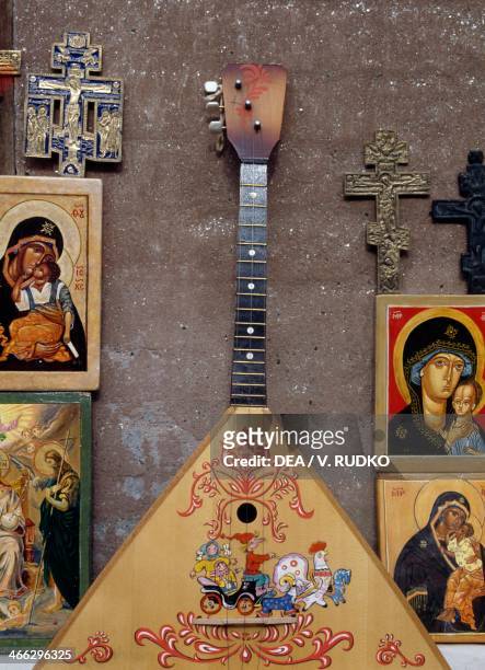 Display case with sacred images, crucifixes and a balalaika, Moscow, Russia.