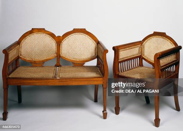 Teak sofa and armchair, wicker seats. Colonial period, English origin, 20th century.