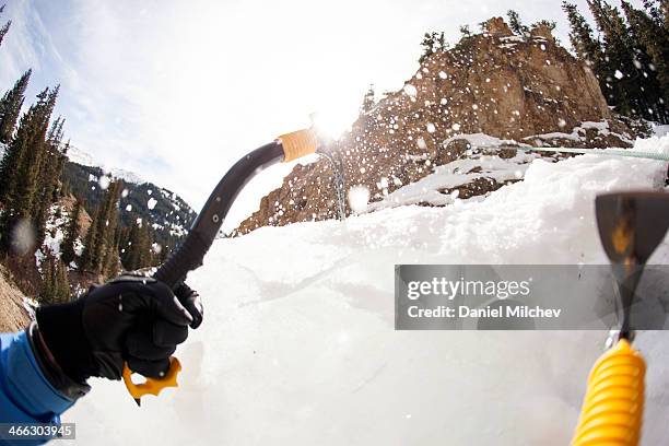 ce climber on a frozen waterfall. - icepick stock-fotos und bilder