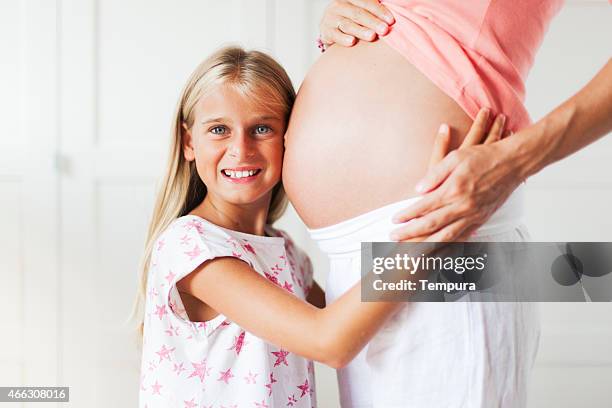 daughter and pregnant mother happy with anticipation - belly kissing stock pictures, royalty-free photos & images