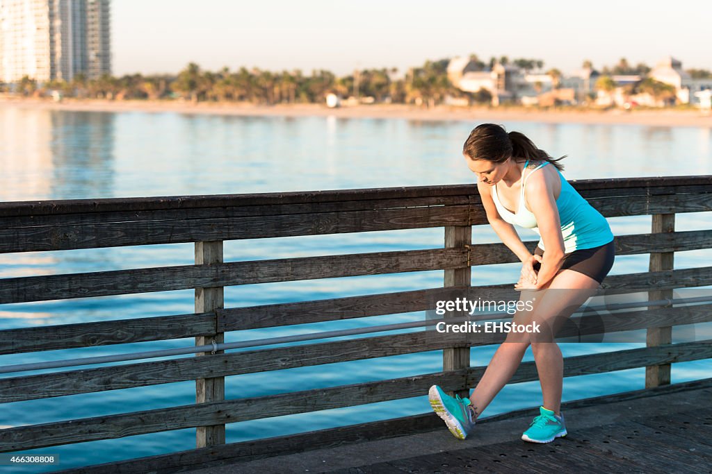 Woman Runner Stretching on Pier