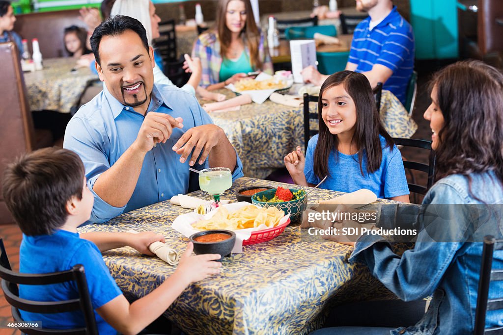 Hispanic parents having dinner in casual Tex-Mex restaurant with kids