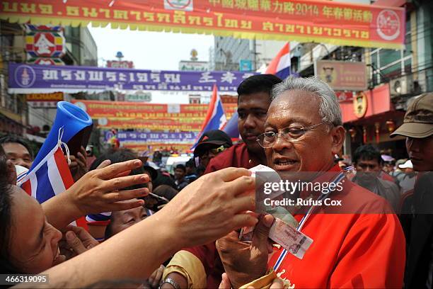 Anti-government protest leader Suthep Thaugsuban receives cash donations from supporters while marching through Chinatown on February 1, 2014 in...