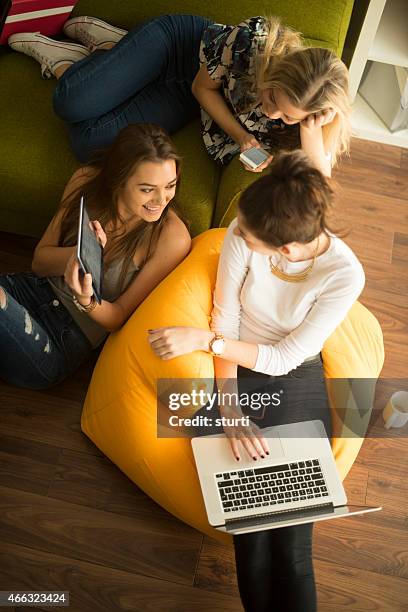 young female students using a technology - bean bag stock pictures, royalty-free photos & images